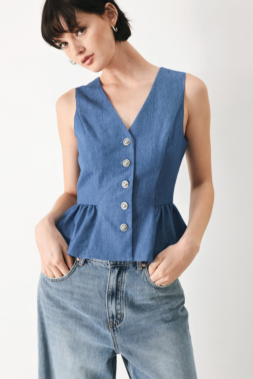 Woman wearing woven blue vest with front closure, sleeveless and peplum | FREEMARKET
