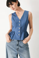 Woman wearing woven blue vest with front closure, sleeveless and peplum | FREEMARKET
