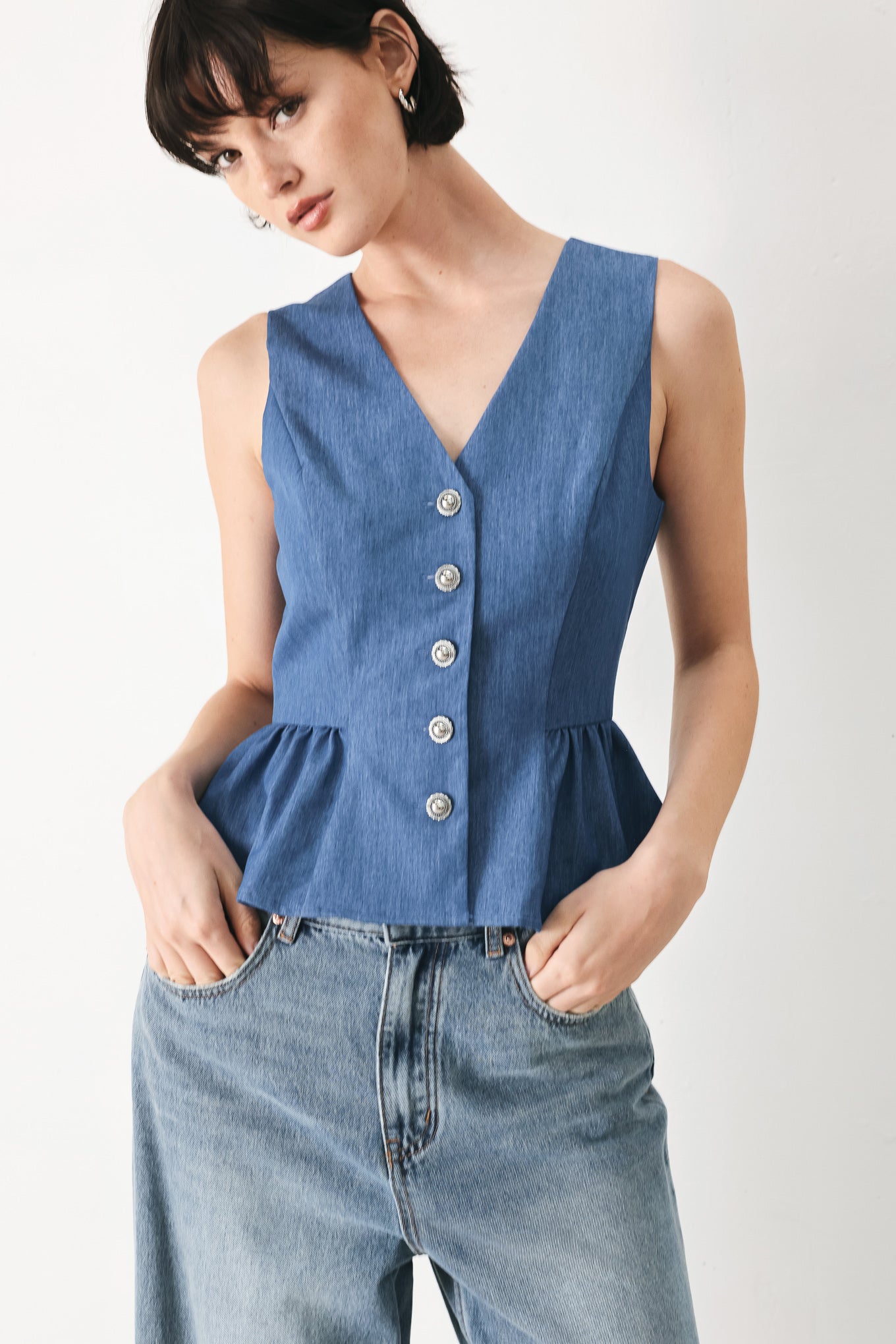 Woman wearing woven blue vest with front closure, sleeveless and peplum | FREEMARKET