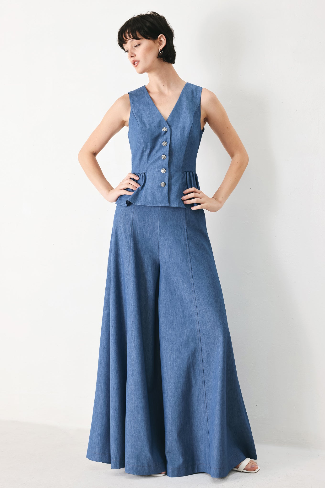 Woman wearing woven blue vest with front closure, sleeveless and peplum | FREEMARKET