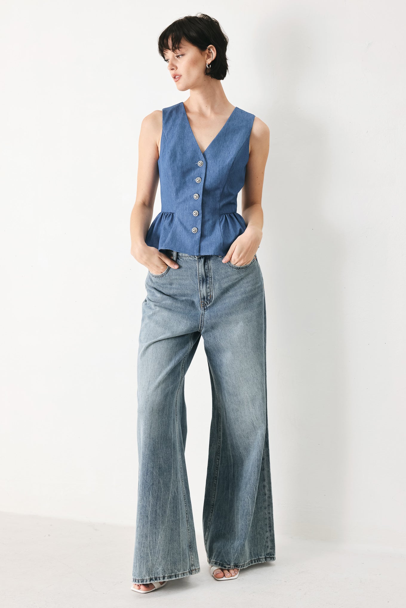 Woman wearing woven blue vest with front closure, sleeveless and peplum | FREEMARKET