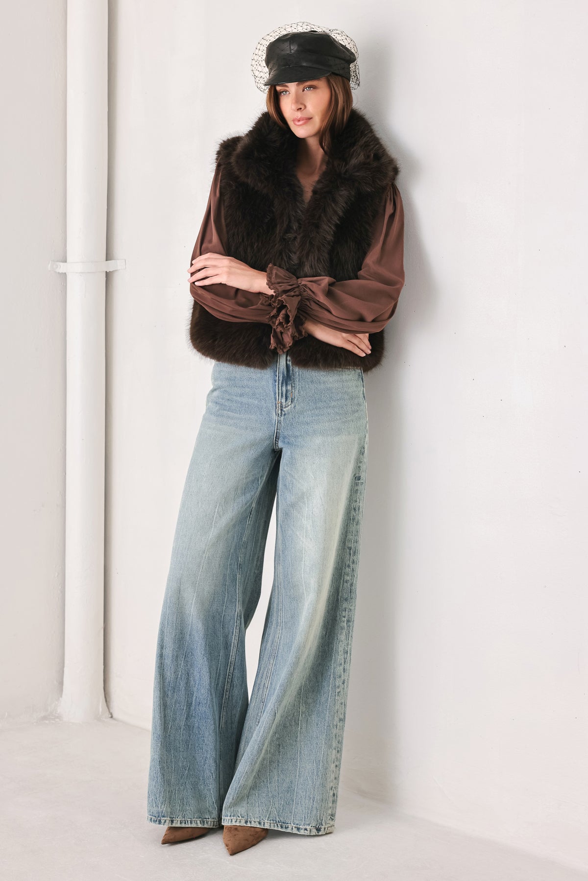 A model wearing a brown faux fur vest over a brown long-sleeve top, paired with wide-leg light blue jeans | FREEMARKET