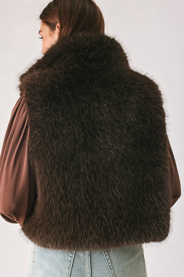 A model wearing a brown faux fur vest over a brown long-sleeve top, paired with wide-leg light blue jeans | FREEMARKET