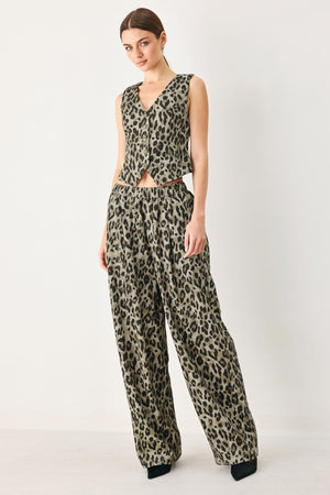 Woman wearing a brown and black leopard print vest with buttons | FREEMARKET