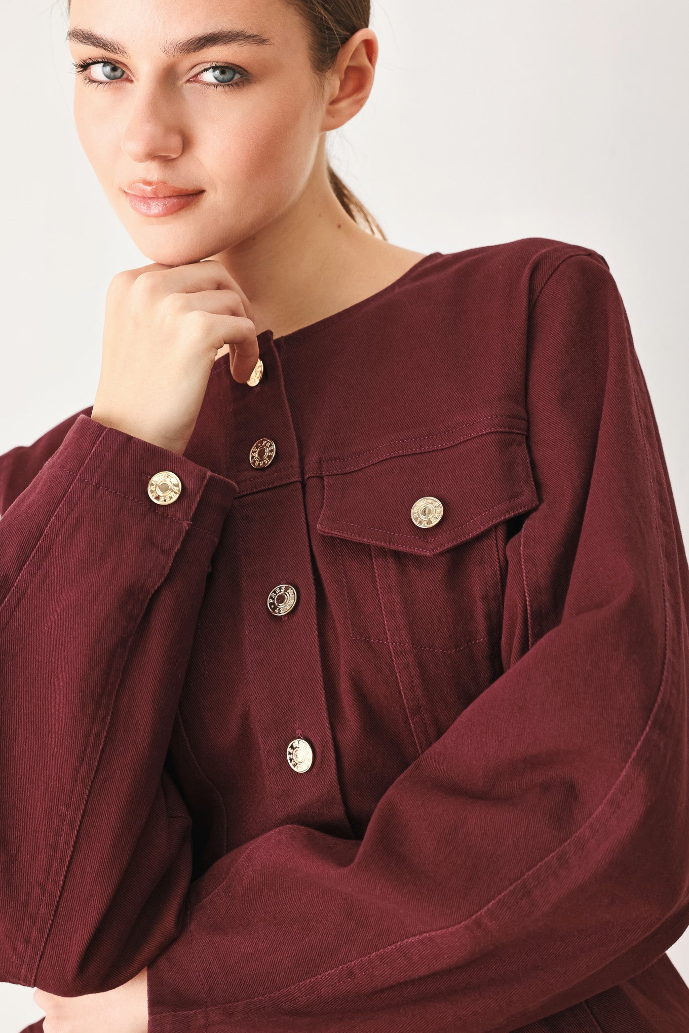 Woman wearing a long-sleeve jacket in deep burgundy with gold-tone buttons | FREEMARKET