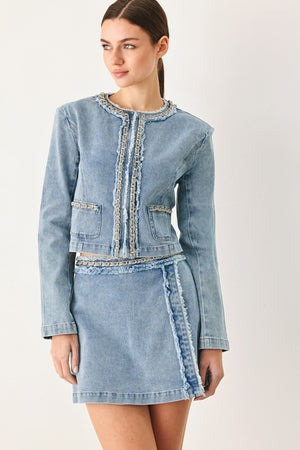Woman wearing a light blue denim jacket featuring decorative gold chain trim and frayed details | FREEMARKET