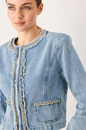 Woman wearing a light blue denim jacket featuring decorative gold chain trim and frayed details | FREEMARKET