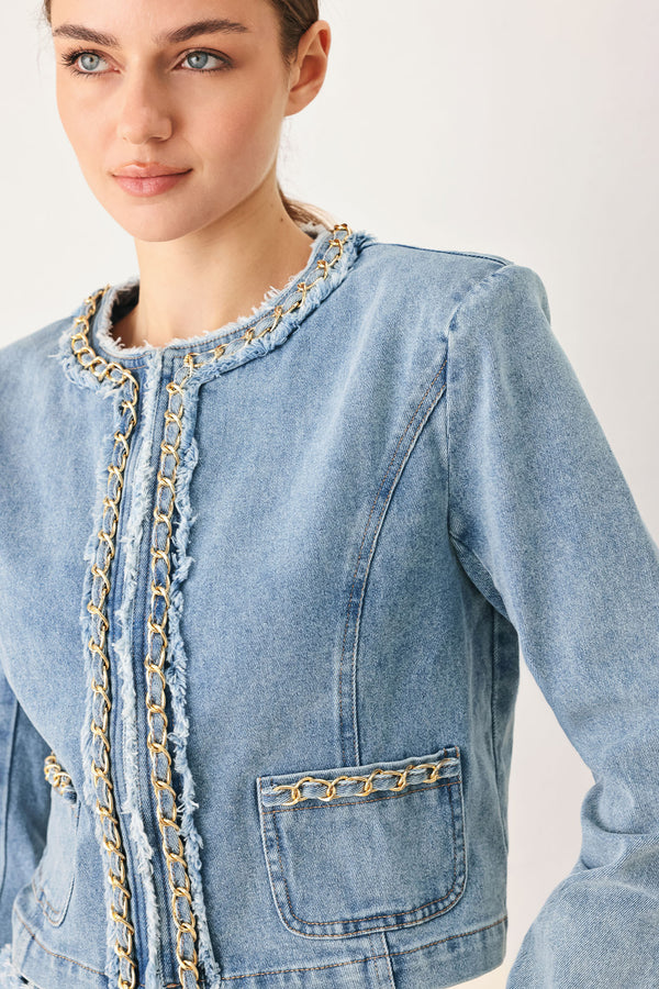 Woman wearing a light blue denim jacket featuring decorative gold chain trim and frayed details | FREEMARKET