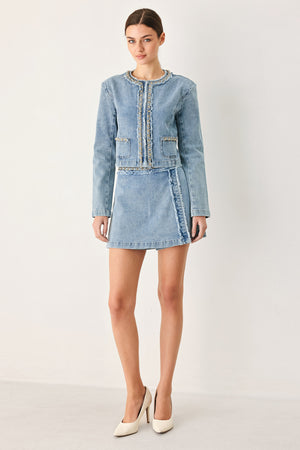 Woman wearing a light blue denim jacket featuring decorative gold chain trim and frayed details | FREEMARKET