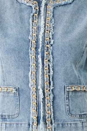 Woman wearing a light blue denim jacket featuring decorative gold chain trim and frayed details | FREEMARKET