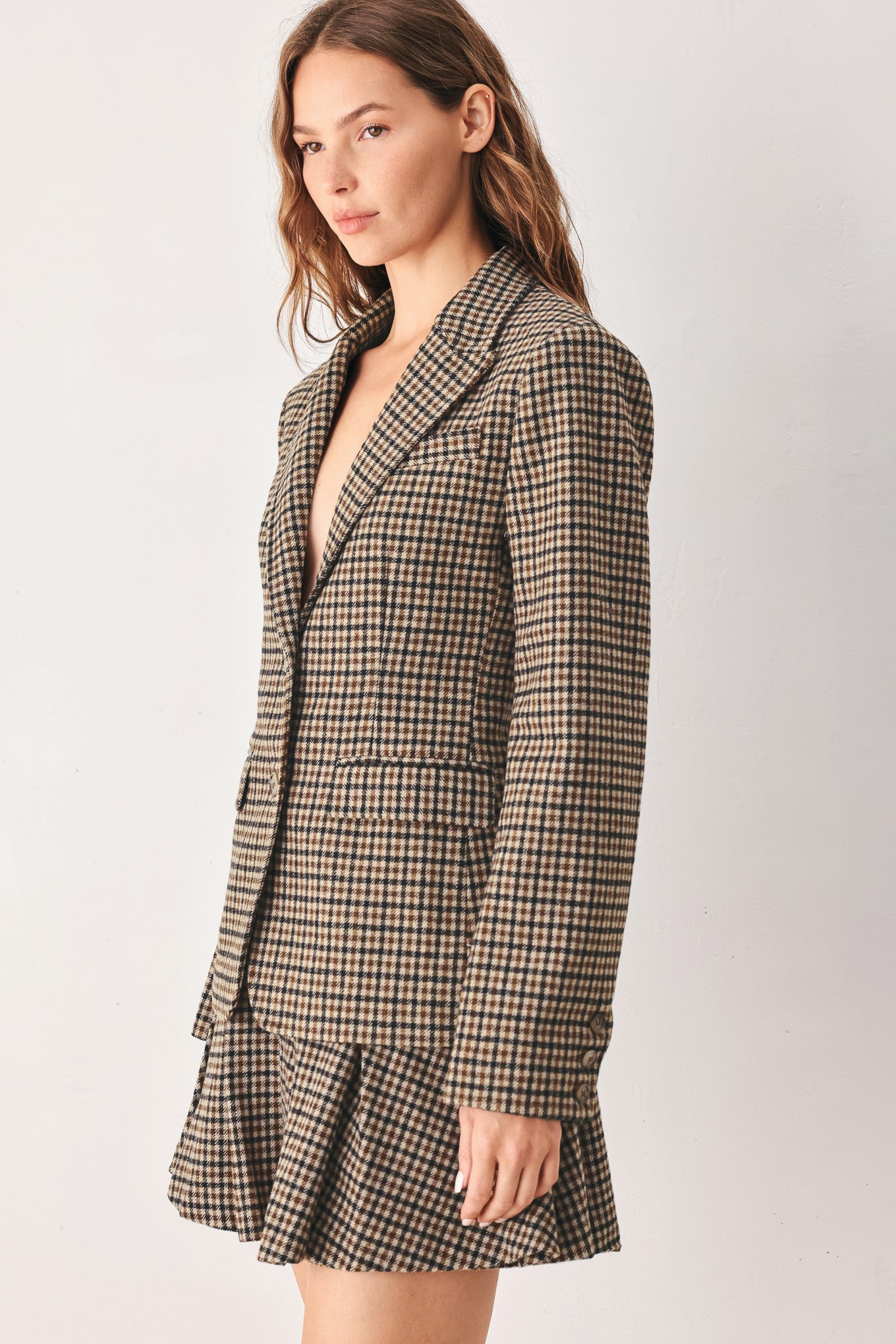 A woman modeling a matching two-piece blazer in a brown and beige houndstooth pattern | FREEMARKET