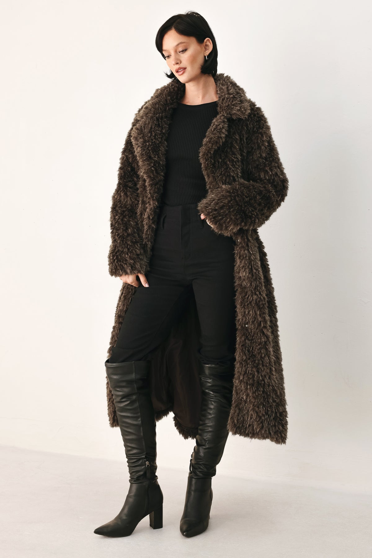 A woman modeling a long, dark brown shaggy faux-fur coat | FREEMARKET