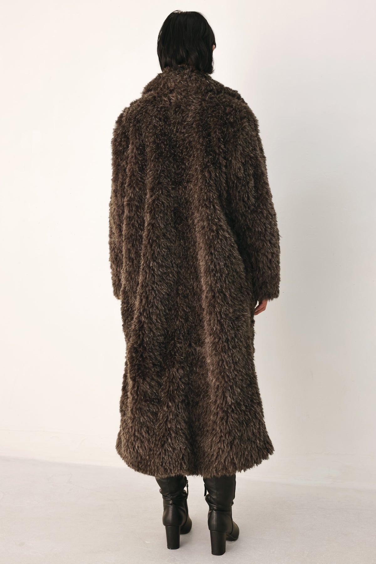A woman modeling a long, dark brown shaggy faux-fur coat | FREEMARKET