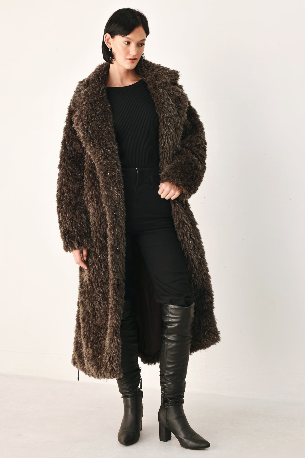 A woman modeling a long, dark brown shaggy faux-fur coat | FREEMARKET