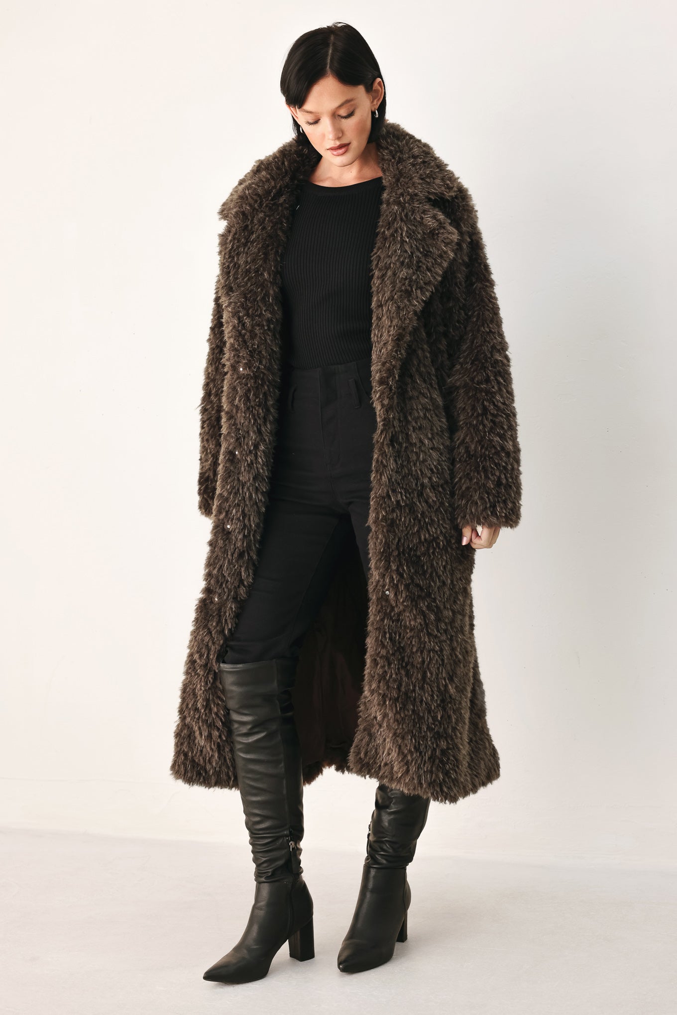 A woman modeling a long, dark brown shaggy faux-fur coat | FREEMARKET
