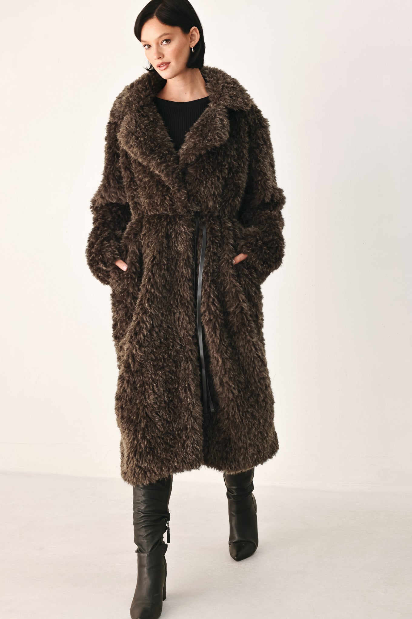 A woman modeling a long, dark brown shaggy faux-fur coat | FREEMARKET