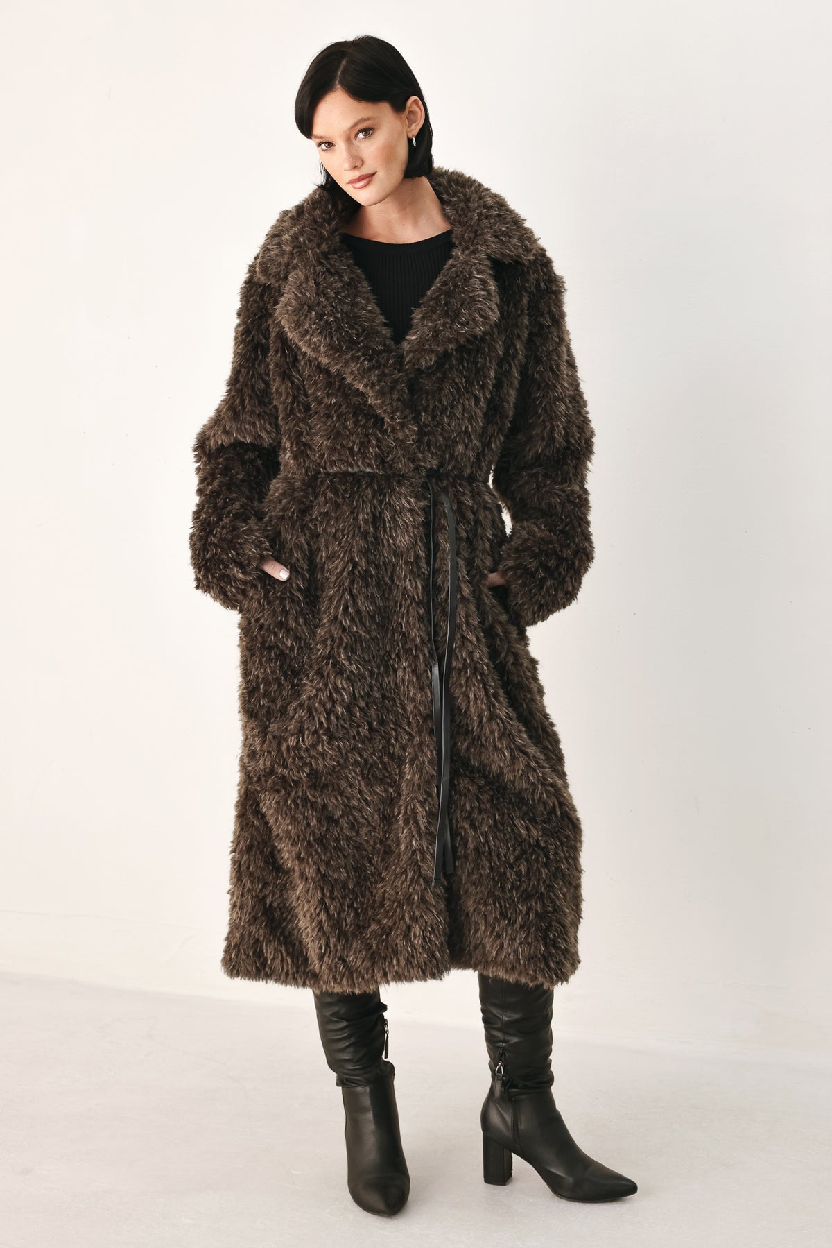 A woman modeling a long, dark brown shaggy faux-fur coat | FREEMARKET