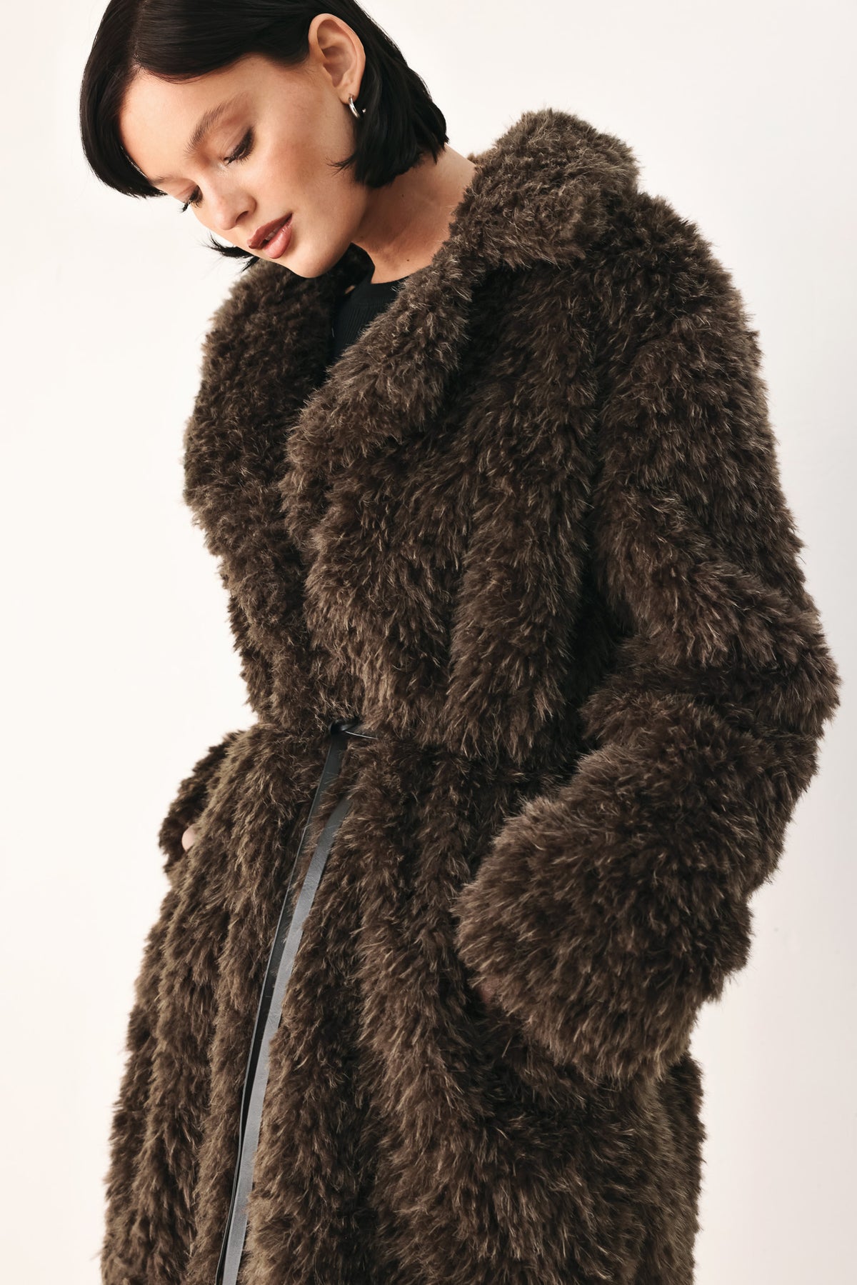 A woman modeling a long, dark brown shaggy faux-fur coat | FREEMARKET