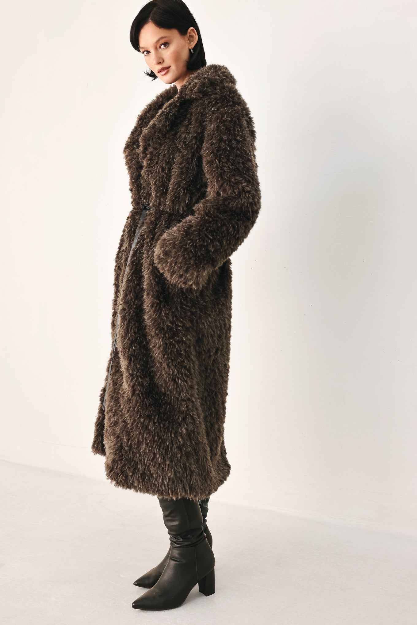 A woman modeling a long, dark brown shaggy faux-fur coat | FREEMARKET