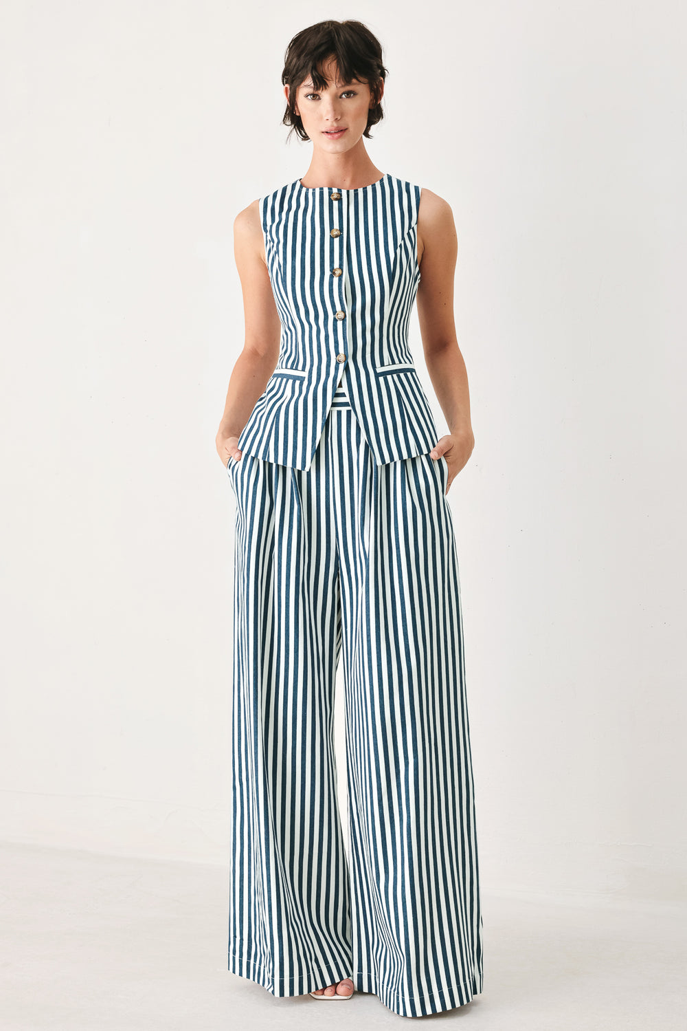 Woman wearing a blue and white striped sleeveless vest with buttons | FREEMARKET