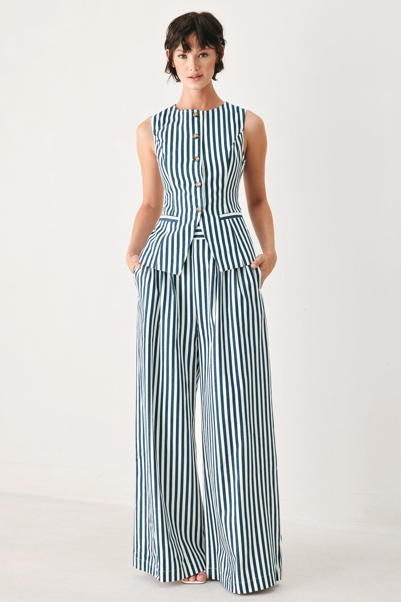 Woman wearing a blue and white striped sleeveless vest with buttons | FREEMARKET