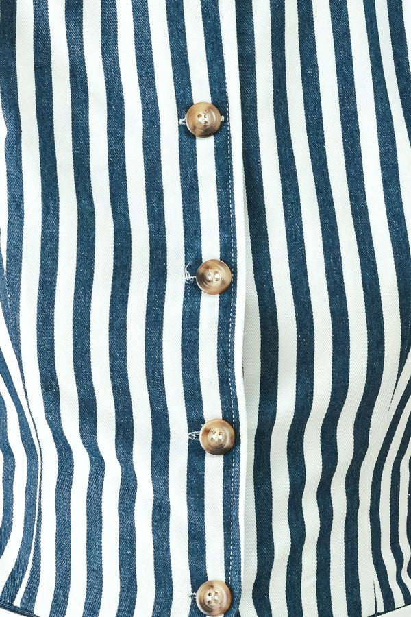 Woman wearing a blue and white striped sleeveless vest with buttons | FREEMARKET