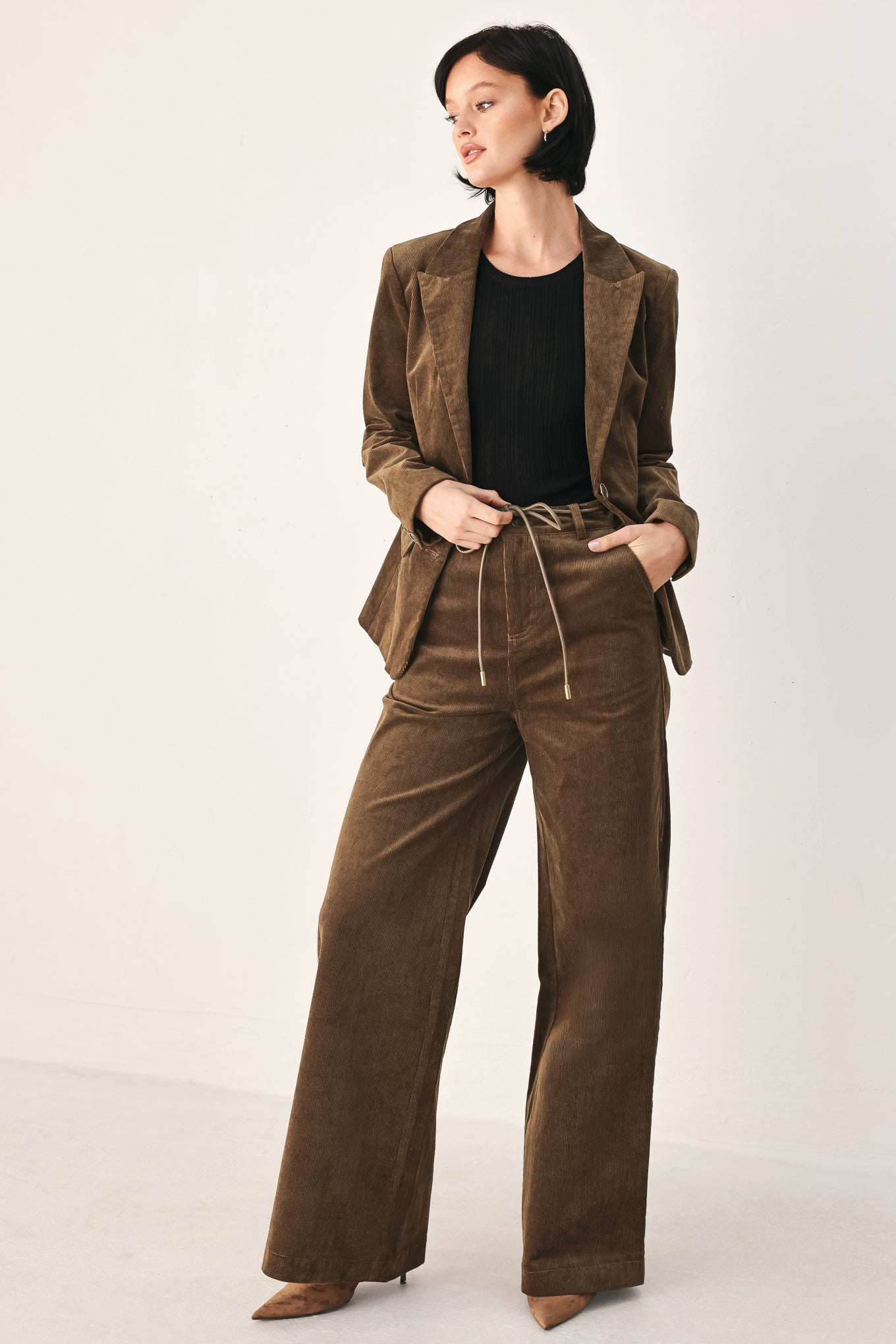 A woman wearing a brown corduroy blazer | FREEMARKET