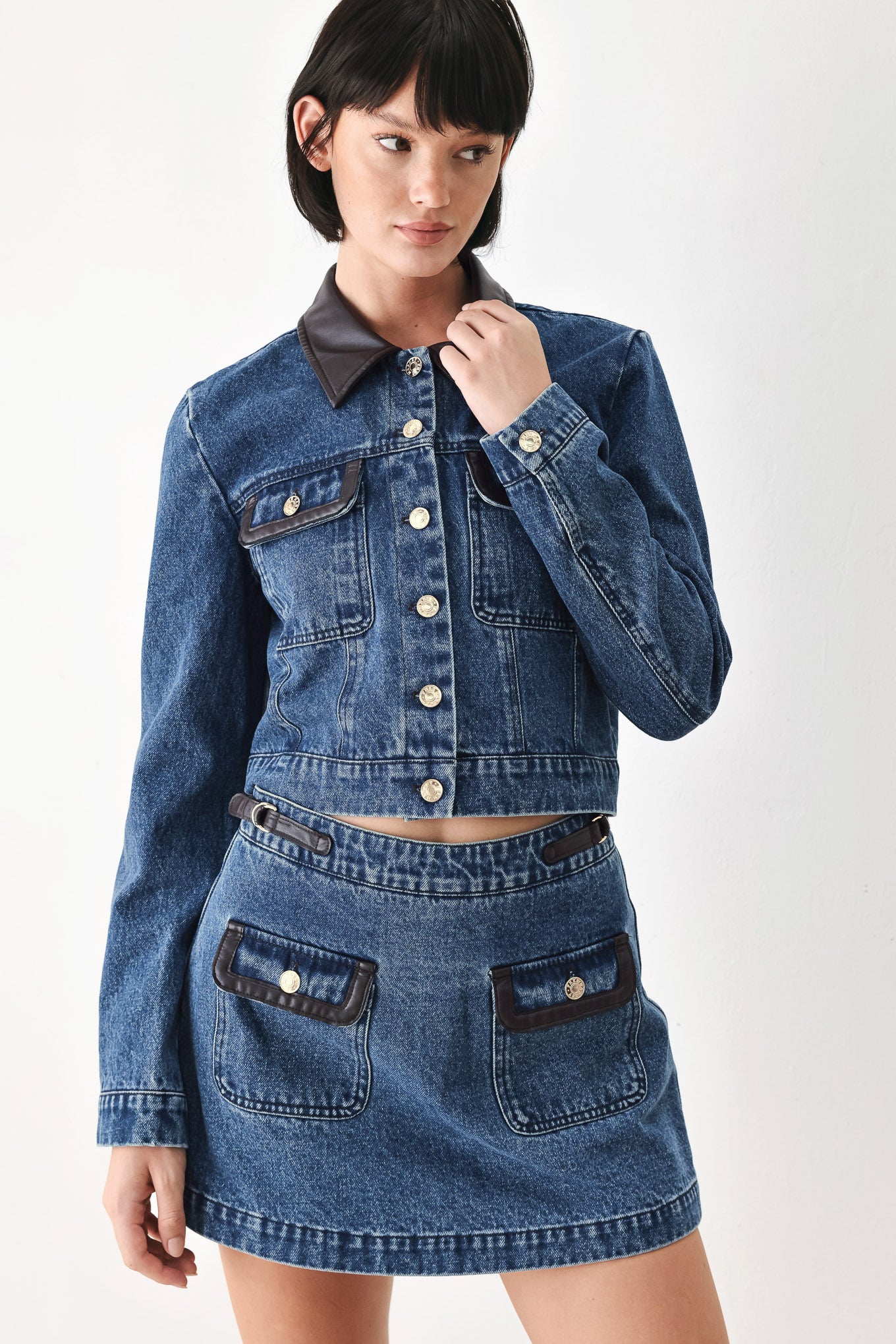 A model wearing a blue denim jacket with dark brown leather-look trim details on the collar | FREEMARKET