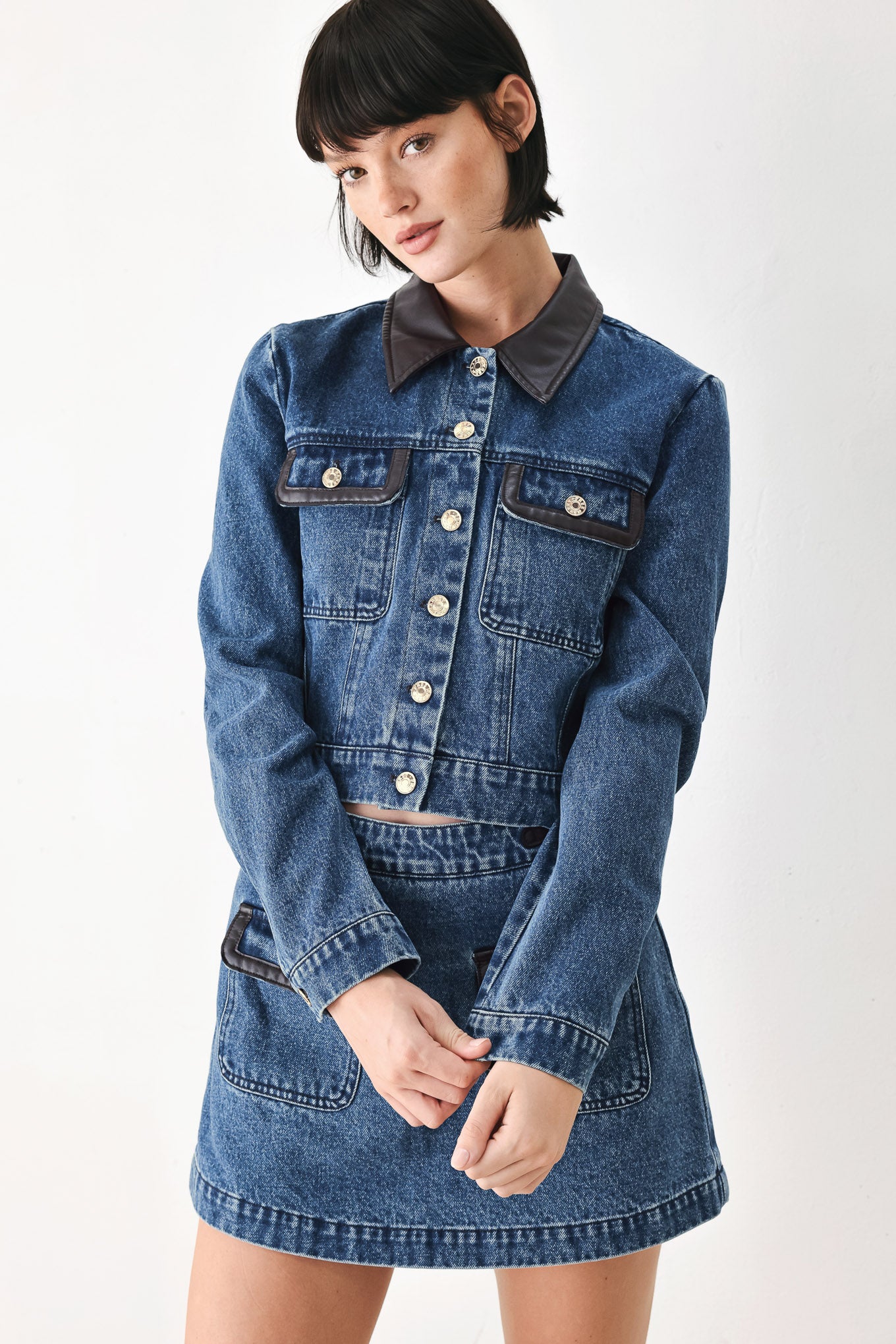 A model wearing a blue denim jacket with dark brown leather-look trim details on the collar | FREEMARKET