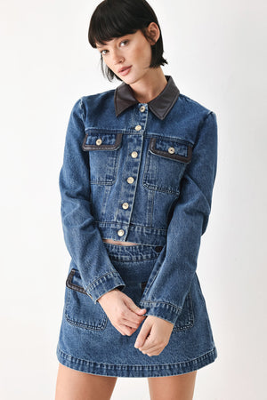 A model wearing a blue denim jacket with dark brown leather-look trim details on the collar | FREEMARKET