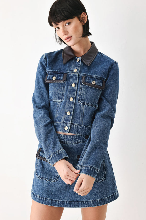 A model wearing a blue denim jacket with dark brown leather-look trim details on the collar | FREEMARKET
