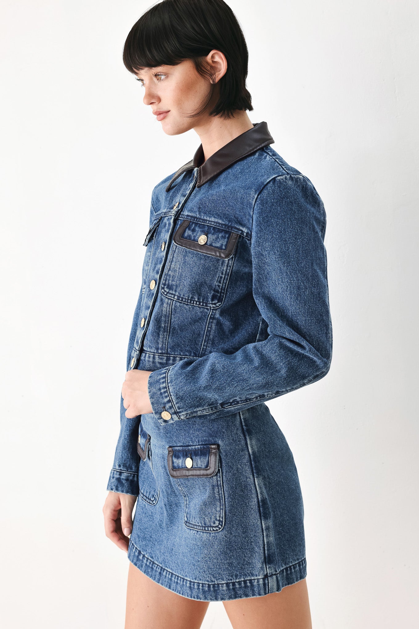 A model wearing a blue denim jacket with dark brown leather-look trim details on the collar | FREEMARKET
