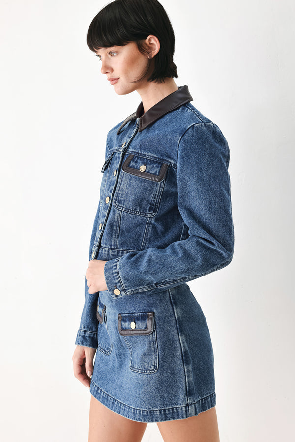 A model wearing a blue denim jacket with dark brown leather-look trim details on the collar | FREEMARKET