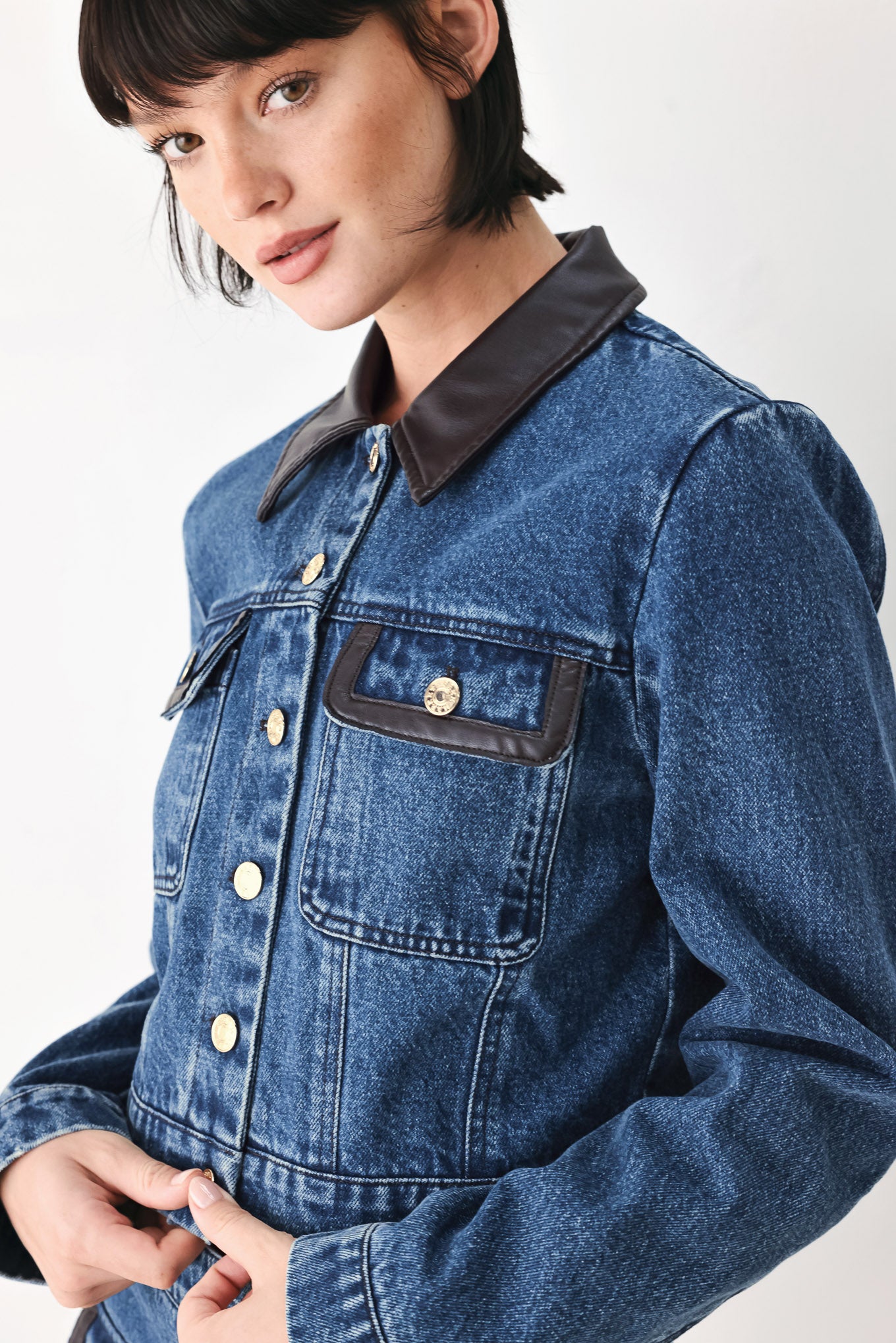 A model wearing a blue denim jacket with dark brown leather-look trim details on the collar | FREEMARKET