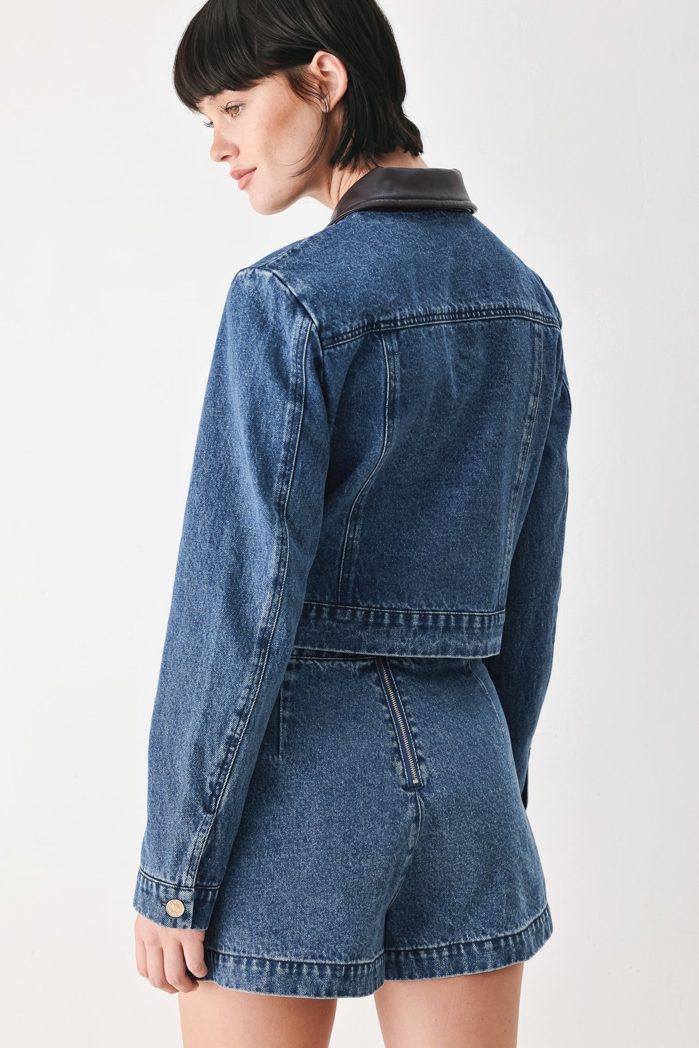 A model wearing a blue denim jacket with dark brown leather-look trim details on the collar | FREEMARKET
