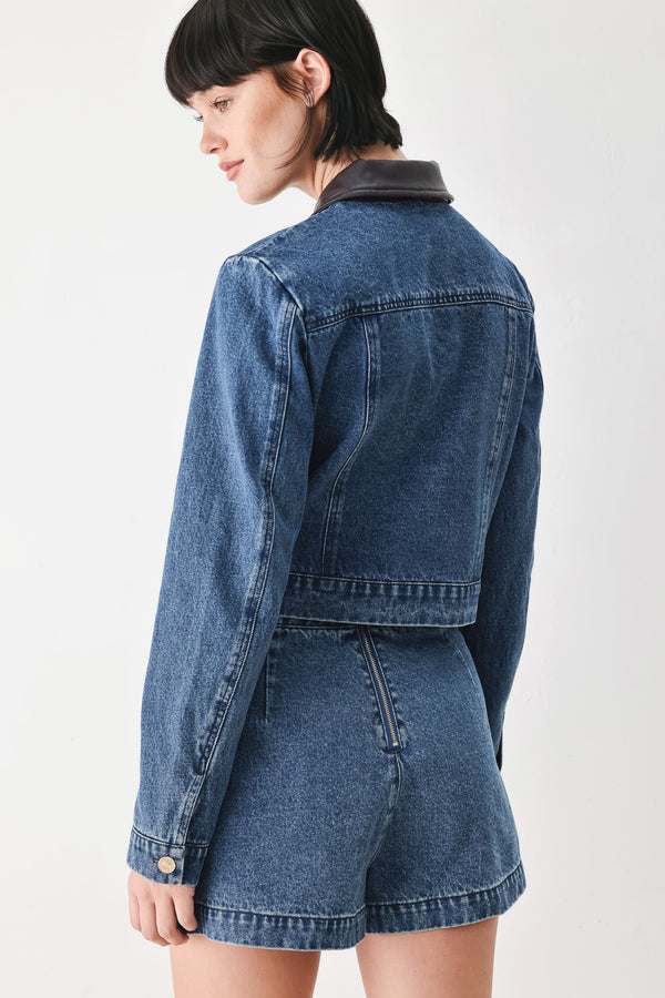 A model wearing a blue denim jacket with dark brown leather-look trim details on the collar | FREEMARKET