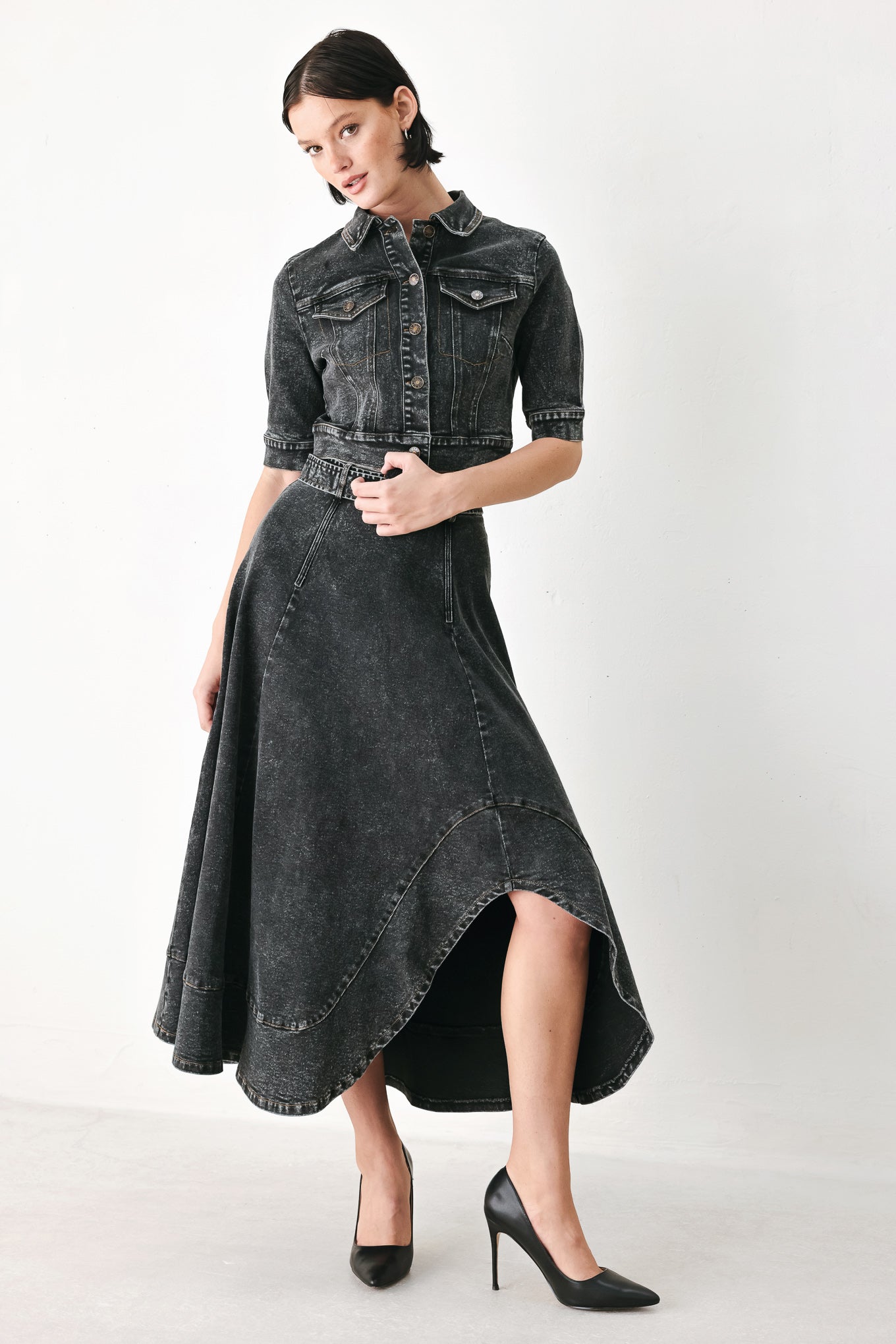 A model wearing a cropped, short-sleeved black acid-wash denim jacket with a band collar and button front | FREEMARKET