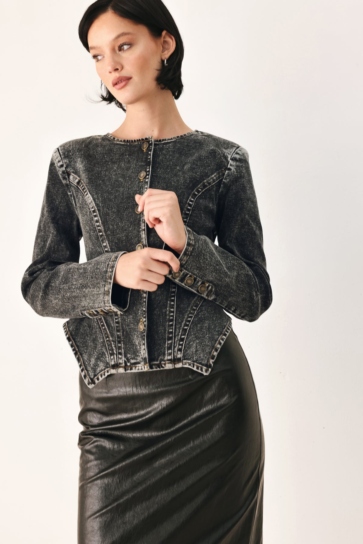 A model wearing a dark gray washed denim jacket with decorative button details down the front | FREEMARKET
