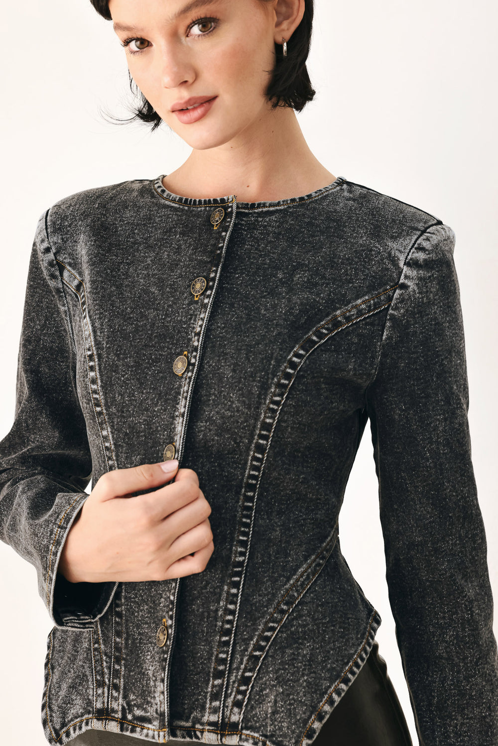 A model wearing a dark gray washed denim jacket with decorative button details down the front | FREEMARKET
