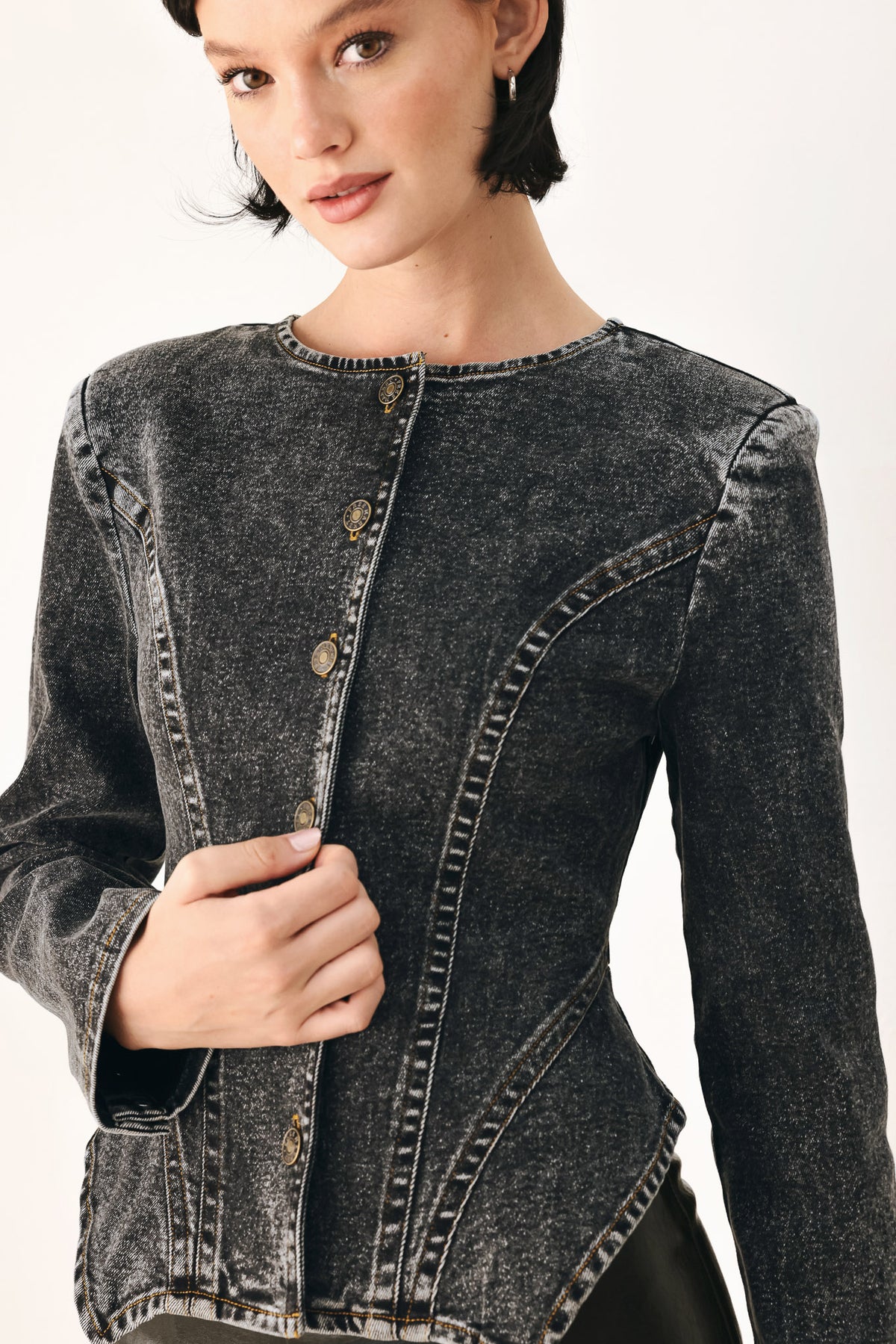 A model wearing a dark gray washed denim jacket with decorative button details down the front | FREEMARKET