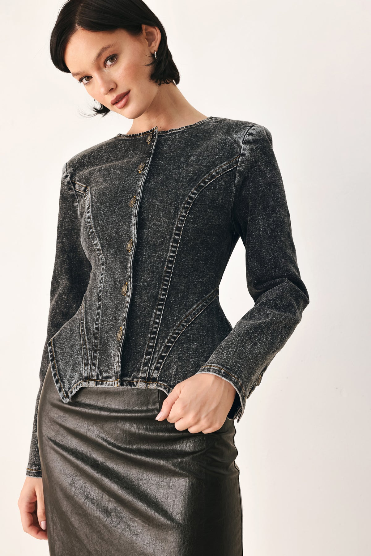 A model wearing a dark gray washed denim jacket with decorative button details down the front | FREEMARKET