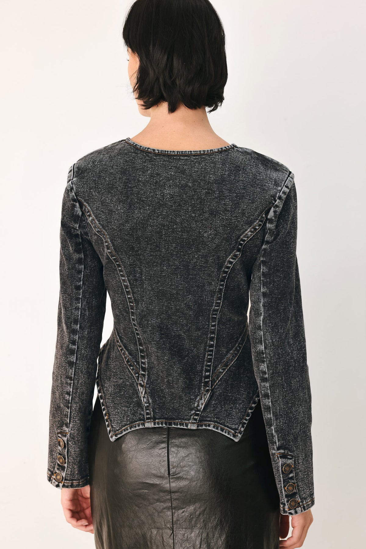 A model wearing a dark gray washed denim jacket with decorative button details down the front | FREEMARKET