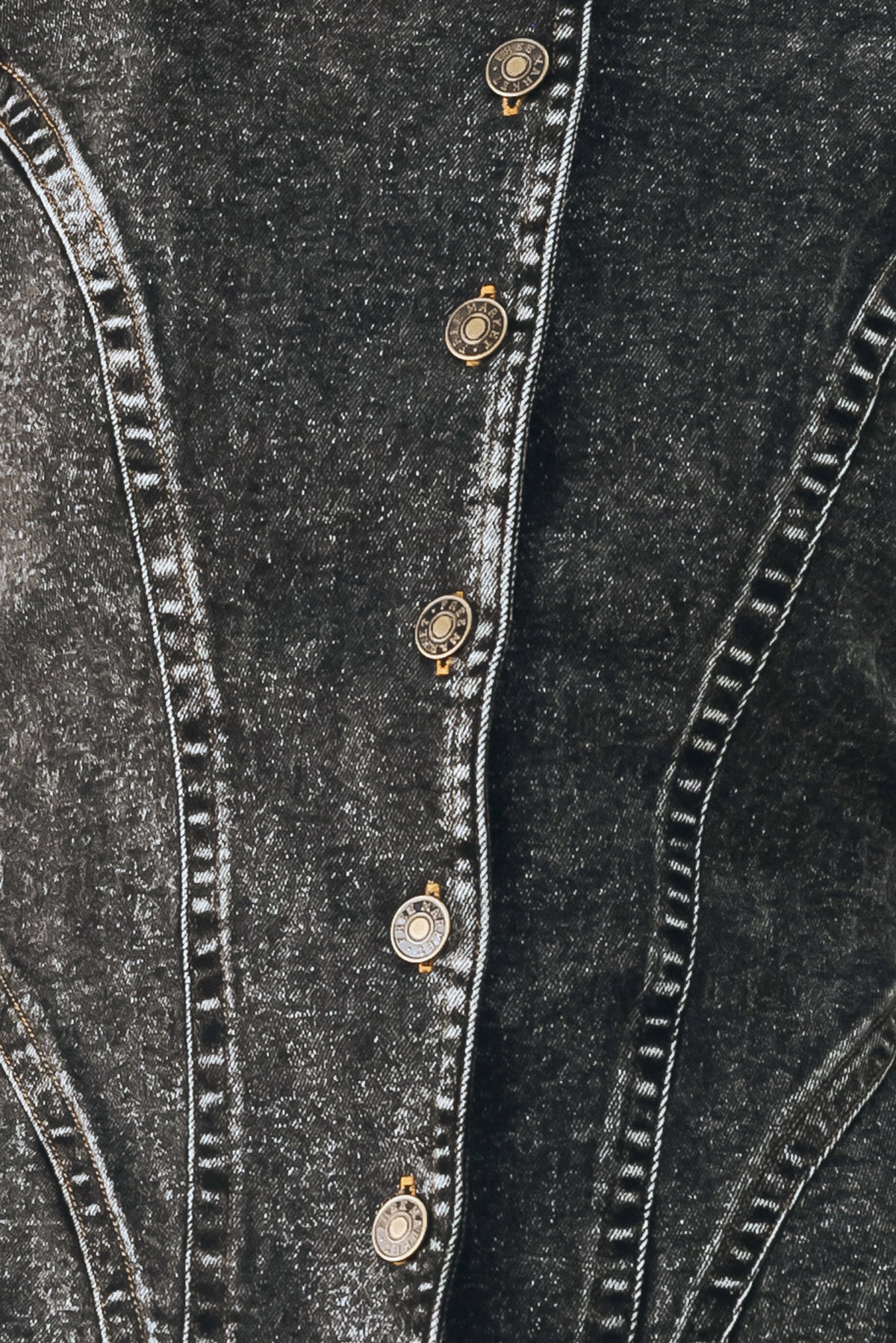 A model wearing a dark gray washed denim jacket with decorative button details down the front | FREEMARKET