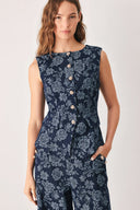 A woman wearing a sleeveless navy blue denim jacquard vest with a light blue floral pattern and gold-tone buttons down the front | FREEMARKET