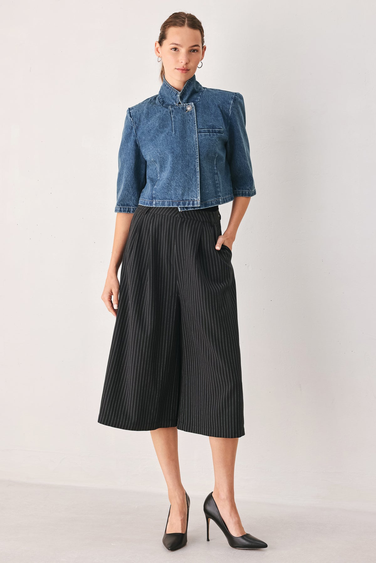 A woman wearing a cropped blue denim jacket with a high stand collar, structured shoulders, and elbow-length sleeves | FREEMARKET