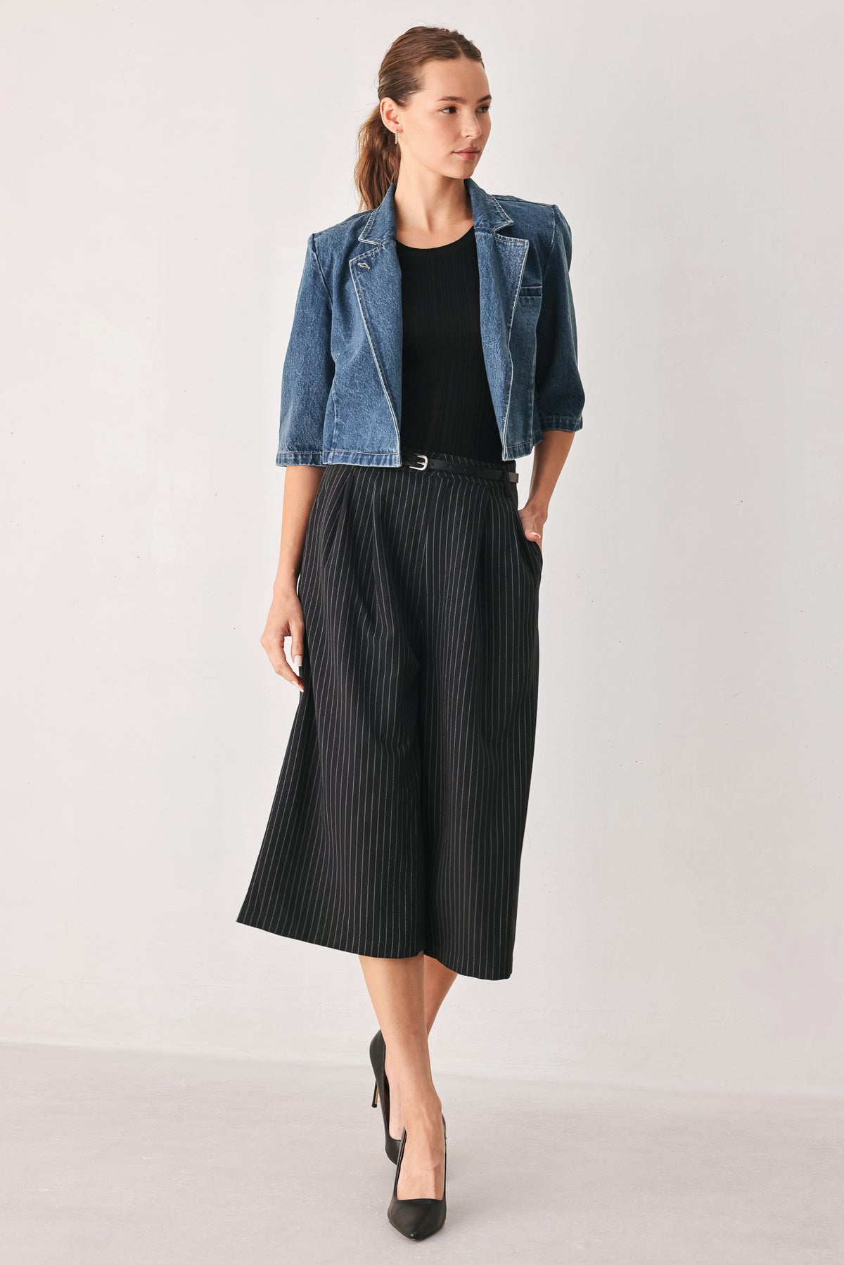 A woman wearing a cropped blue denim jacket with a high stand collar, structured shoulders, and elbow-length sleeves | FREEMARKET