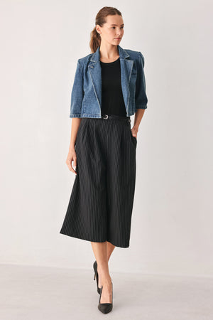 A woman wearing a cropped blue denim jacket with a high stand collar, structured shoulders, and elbow-length sleeves | FREEMARKET