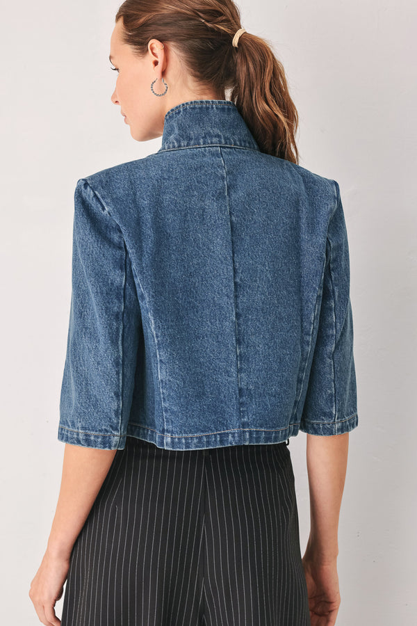 A woman wearing a cropped blue denim jacket with a high stand collar, structured shoulders, and elbow-length sleeves | FREEMARKET