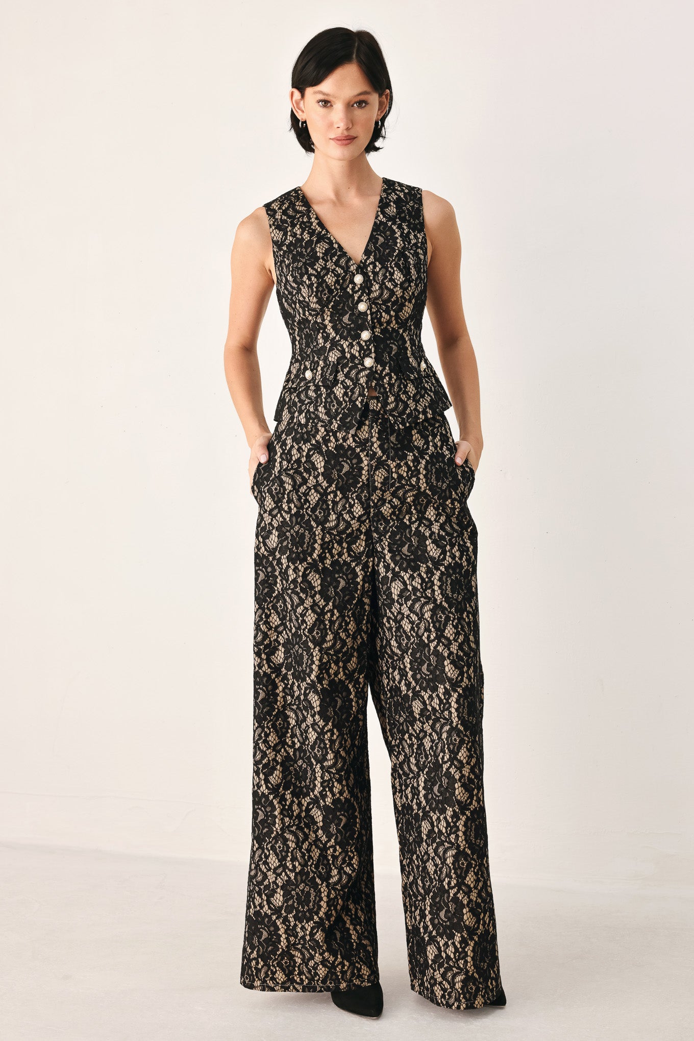 A woman wearing a sleeveless black lace vest with a V-neckline, front buttons | FREEMARKET