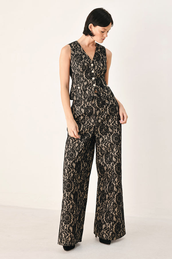 A woman wearing a sleeveless black lace vest with a V-neckline, front buttons | FREEMARKET